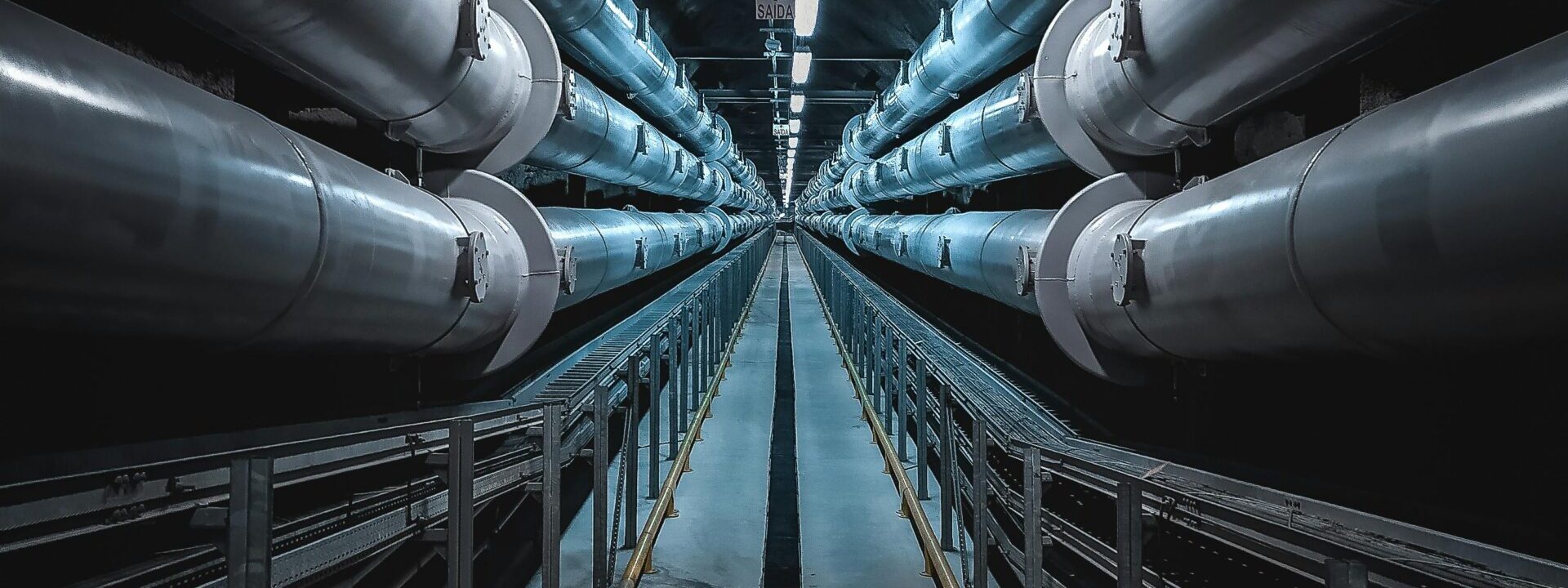 pexels-photo-3421636-3421636 A dramatic view of a symmetric industrial tunnel lined with steel pipes.